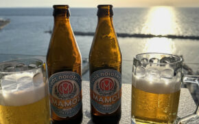 Ein kühles Bier bei Sonnenuntergang am Meer.